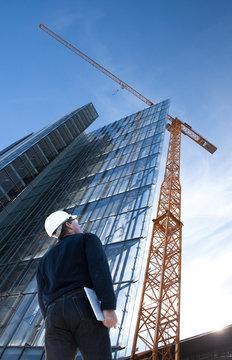 Architect,engineer with laptop,tablet on construction site checking building