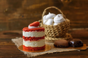 cake with strawberries, biscuits and a Cup of tea on a wooden table