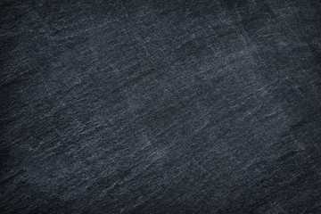 Dark grey / black slate stone background or texture.