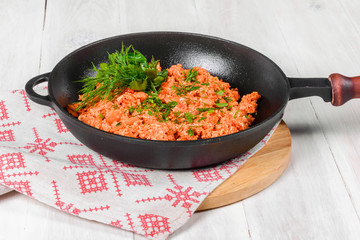 Scrambled eggs in a cast-iron black frying pan