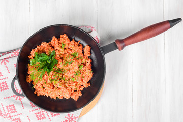 Scrambled eggs in a cast-iron black frying pan