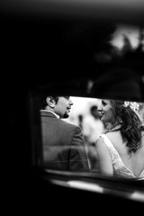 Look from the inside a retro car at wedding couple walking outside along the street