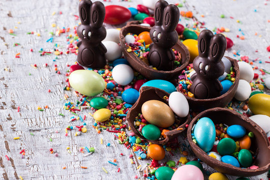Delicious chocolate easter eggs ,bunny and sweets on wooden background