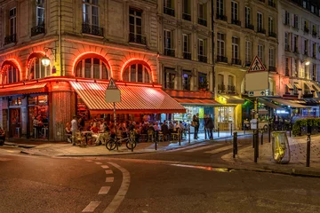 Tuinposter Cozy street with tables of cafe in Paris at night, France © Ekaterina Belova