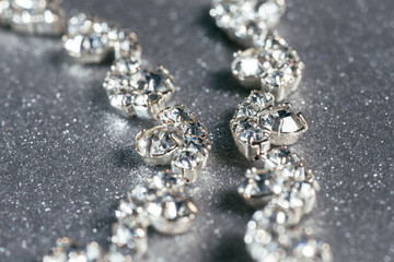 Silver necklace with diamonds close-up on a grey background