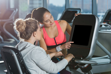 overweight woman starting to doing cardio while trainer helping her