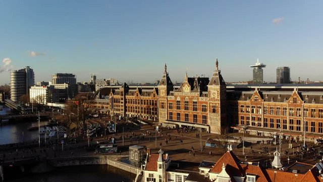 The train station of Amsterdam in an aerial shot. The camera moves slowly downwards.