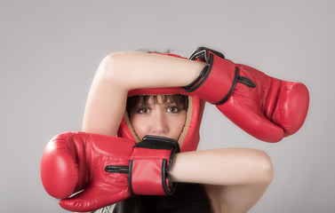 Woman wearing boxing gloves and a red headguard