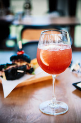 Refreshing red citrus cocktail punch with fresh lemon slice in wine glass