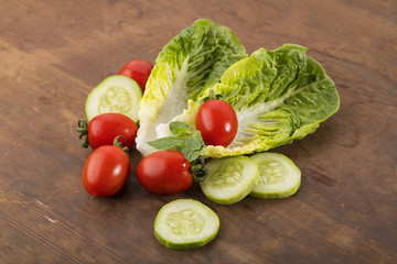 
Vegetable: Fresh Green Romaine Lettuce with Baby Tomatoes, Mint Leaves and Cucumber Slices on Brown Wooden Background
