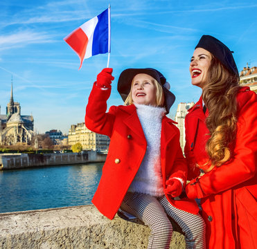 stylish mother and child travellers in Paris, France rising flag