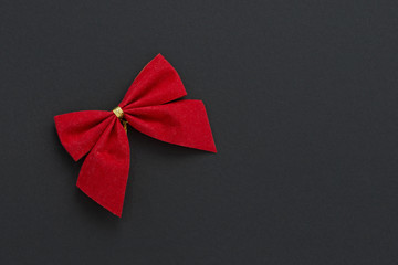Gift realistic red bow and ribbons tilted on a black