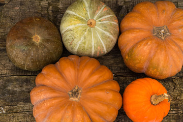 Pumpkins in basket on rustic vintage background on wooden table