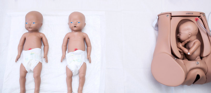 A set of children's dummies for doctors. Mother of the mother's maternity head, practical research and preliminary treatment. Medetsinskaya doll of a newborn lung disease. background