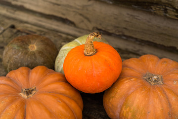 Pumpkins in basket on rustic vintage background on wooden table