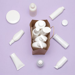 Paper bag filled with cosmetic products and surrounded by ones
