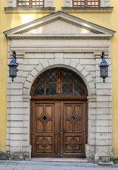 Old vintage wooden doors in an ancient architectural building with vintage wrought-iron lanterns