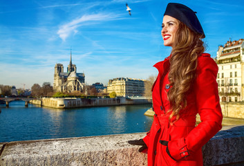 tourist woman in red trench coat in Paris, France looking aside