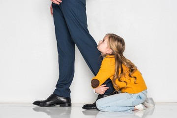 little daughter hugging father in business suit isolated on grey, loneliness concept