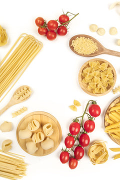 Overhead photo of different types of pasta with cherry tomatoes on white with copy space