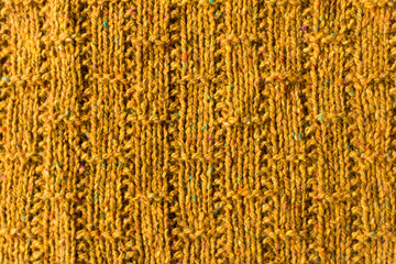 Crafted surface: close up view of mustard color knitted pattern swatch