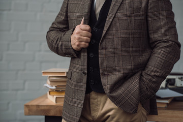 cropped shot of senior writer in stylish tweed suit near workplace