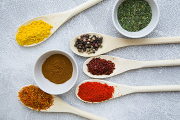 Set of spices and herbs on light stone background