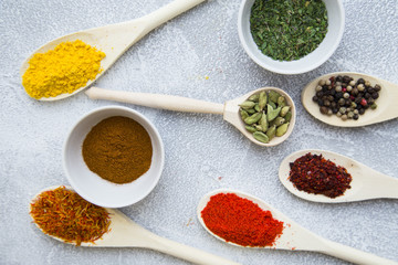 Set of spices and herbs on light stone background