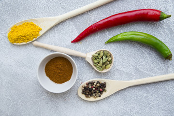 Set of spices and herbs on light stone background