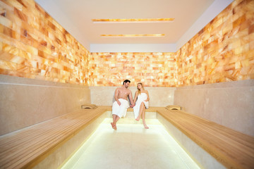 Couple in towels resting in the sauna. Man and woman in a spa salon.