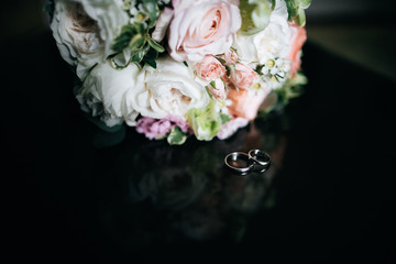 Wedding bouquet of white and pink flowers and wedding rings