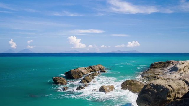 a pebble beach and Mediterranean sea with the Aeolian islands in the distance in Sicily, Italy.
