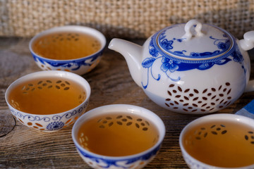 Obraz na płótnie Canvas porcelain teapot and bowls with green tea