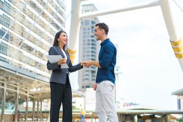 Beautiful asian businesswoman shaking hands with handsome man for success business solution. concept of communication, negotiation and business together.