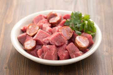 raw meat with smoked sausages on plate