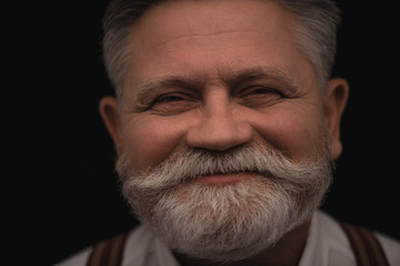 Obraz premium happy senior man looking at camera isolated on black