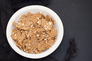 flakes in white bowl on black background