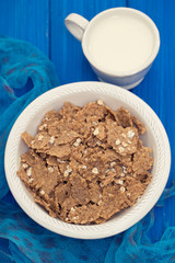 flakes in white bowl on wooden  background