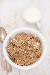 flakes in white bowl on wooden  background