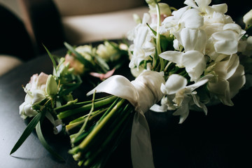A beautiful wedding bouquet of brides from white flowers on a dark wooden background
