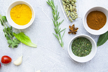 Set of spices and herbs on light stone background