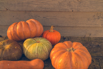 Orange autumn pumpkins on the old rustic table with vintage film colours background