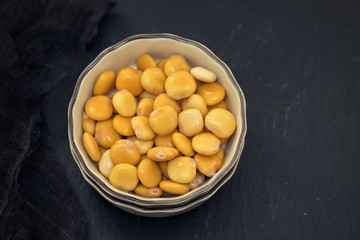 salted lupins in bowl on wooden background