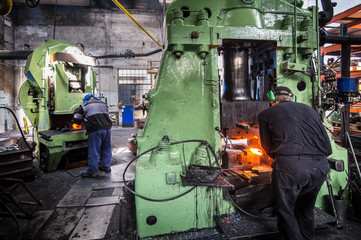 metal forging, forging shop. hydraulic hammer shapes the red-hot billet. the production of...