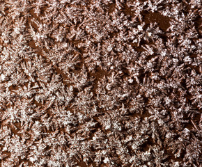 A snowflake on a brown fence as a background