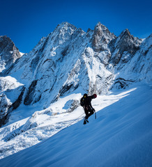 Young man climbing up on glacier in big mountain, massive Mont Blanc, Chamonix