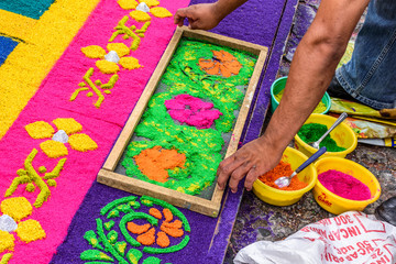 Decorating dyed sawdust Holy Thursday carpet, Antigua, Guatemala