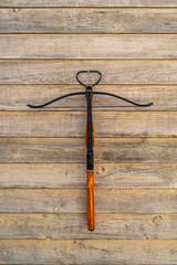 Hunter crossbow on a wooden wall with a light vintage
