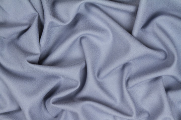 Fototapeta premium Blue woolen crumpled wrinkled fabric with waves, background crumpled tissue.
