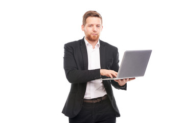 Studio portrait of young manager in suit holding open laptop